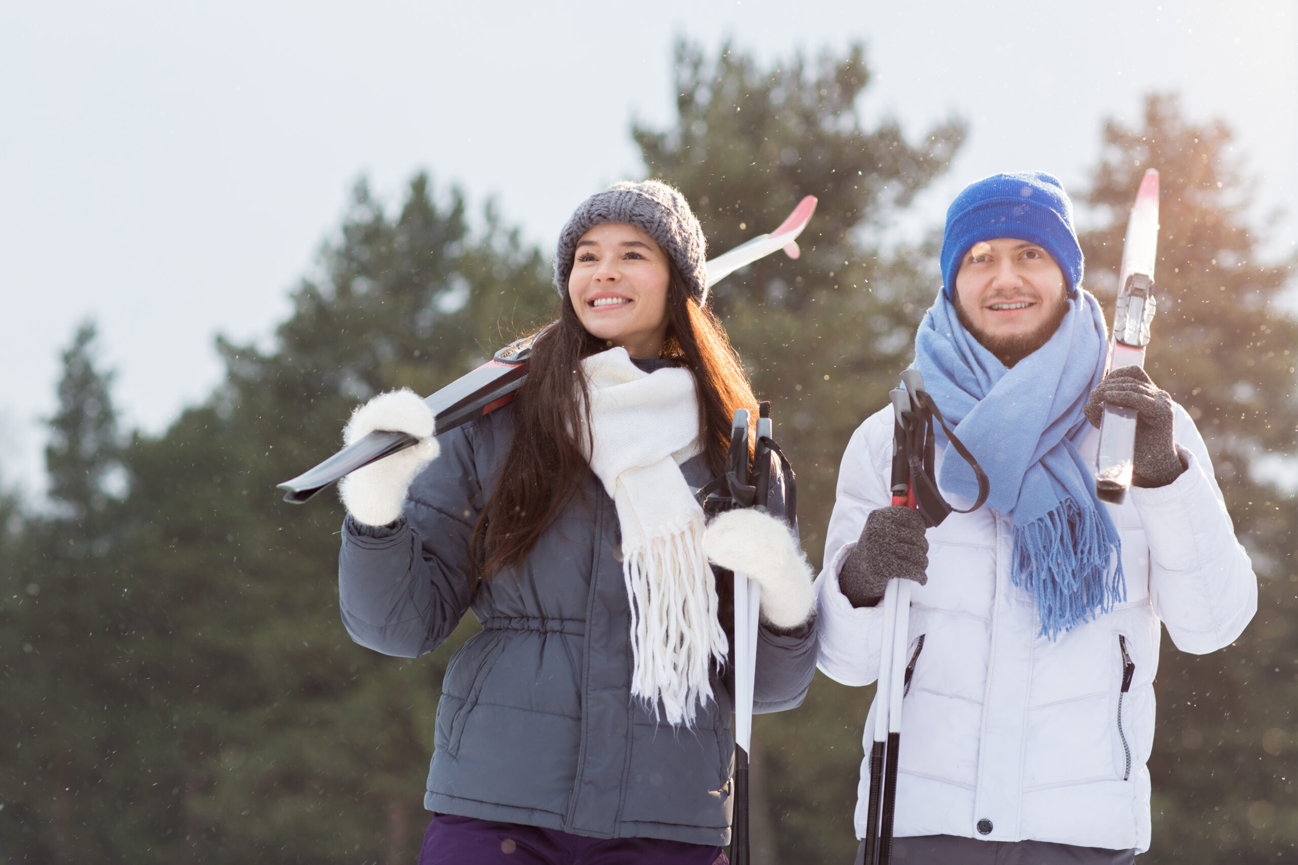 Young sporty man and woman in activewear choosing place to ski on winter weekend
