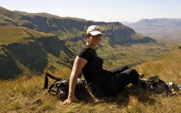La bloguera de viajes de aventura, Laurel Robbins, disfruta de las vistas de las montañas Drakensberg en Sudáfrica