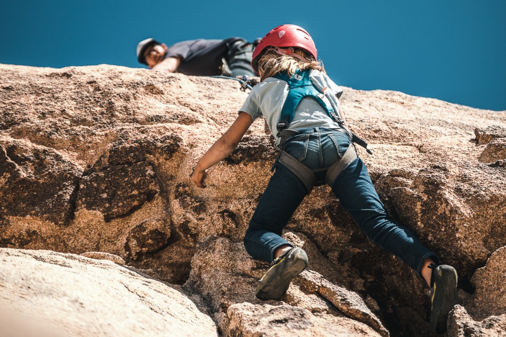 Revisión para niños del arnés de escalada de cuerpo completo Black Diamond Momentum: papÔ asegura desde arriba mientras el triturador de niños detiene el bulto.