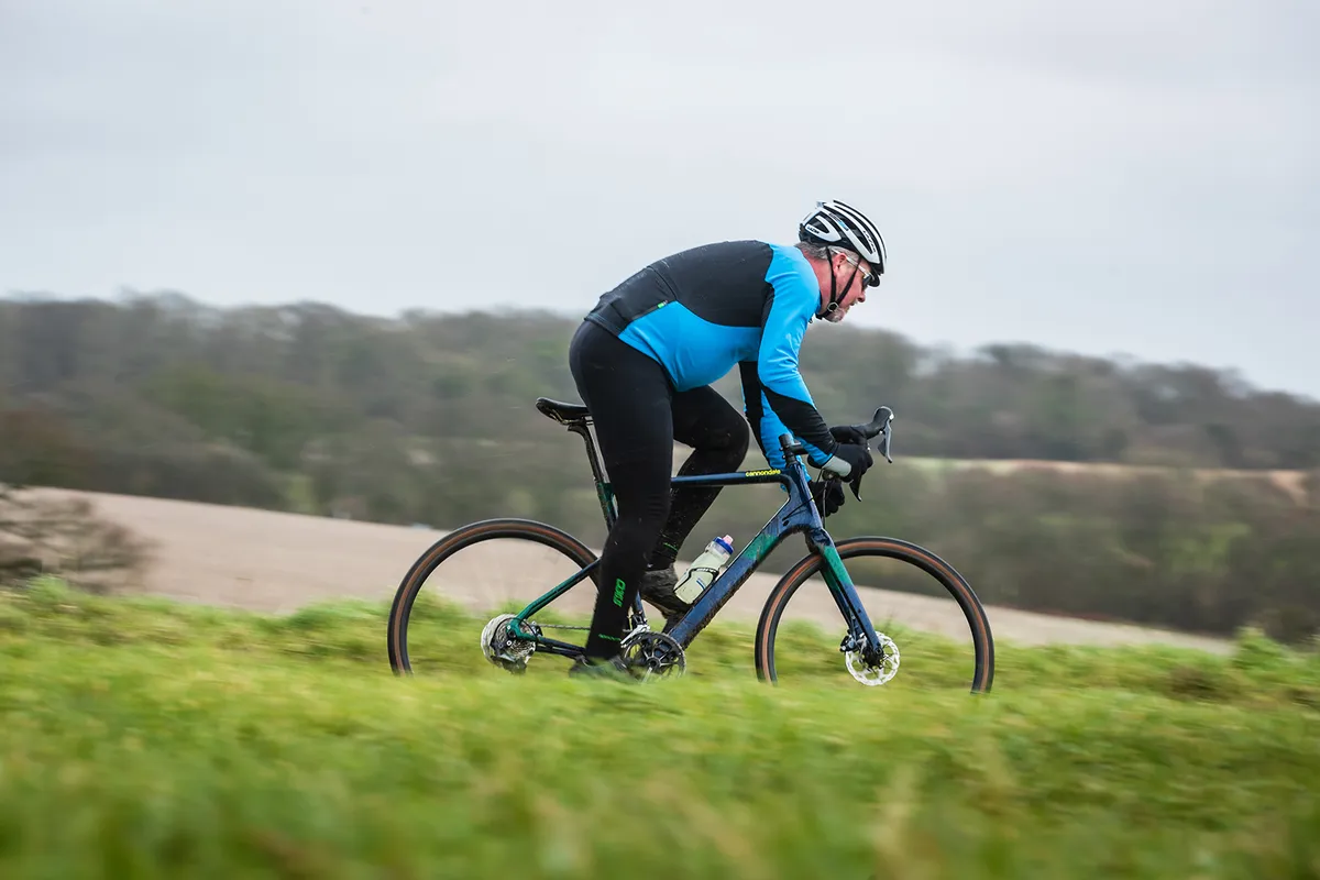 Cannondale Topstone Carbon Ultegra RX Ciclista vestido de azul montando una bicicleta gravel Cannondale Topstone Carbon azul